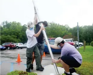  ??  ?? Starkville Scouts BSA Troop 27 Scouts Parker Bazzill, Matt Hill and Clay Huddleston work together to place a flagpole in front of Starkville Manor Wednesday, as part of Bazzill’s Eagle Scout service project. (Photo by Charlie Benton, SDN)