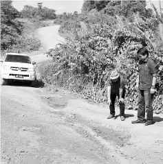  ??  ?? Dennis (right) and a local making a road inspection during a trip in Baram recently.
