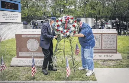  ?? Photos by John Minchillo / Associated Press ?? A motorcade of veterans stops Monday outside the VA Medical Center in Brooklyn as wreaths are lain beside memorial stones on the premises.