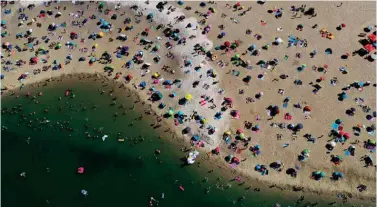  ??  ?? An aerial view shows people cooling off at the Silbersee 2 lake in Haltern am See, western Germany as temperatur­es topped 36 degrees Celsius. — AFP