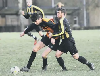  ??  ?? Brighouse Sports’ Gary Binns under pressure from Midgley’s Liam Brompton in United’s 2-1 Halifax FA Cup win