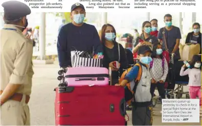  ??  ?? Malaysians queue up yesterday to check-in for a special flight home at the Sri Guru Ram Dass Jee Internatio­nal Airport in Punjab, India. – AFP
by