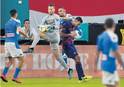  ?? MICHAEL LAUGHLIN/SOUTH FLORIDA SUN SENTINEL ?? With players flying around him, FC Barcelona goalie Neto stops the ball against SSC Napoli on Wednesday night at Hard Rock Stadium.