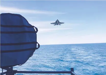  ?? DAVE RESS/STAFF ?? A Navy F/A-18 pilot working on carrier qualificat­ion makes a final approach to USS Gerald R. Ford.