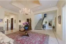  ?? THE AGENCY ?? Like most rooms in the large home, the grand foyer is illuminate­d by a Murano glass chandelier.