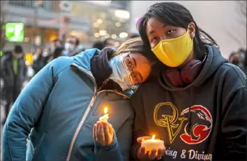  ?? Alexandra Wimley/Post-Gazette ?? Neighbors and friends Lia Warburton and Lydia Callaghan, both of Sewickley, comfort each other as they listen to a speaker during a candleligh­t vigil Sunday in Downtown Pittsburgh.