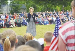  ??  ?? ECS Music Teacher Karen Chapman leads the first-graders as they sing “America” Wednesday morning in observance of Flag Day. Officials estimated that between veterans, the color guard, town leaders, staff, faculty and relatives, total attendance at the ceremony was about 900.