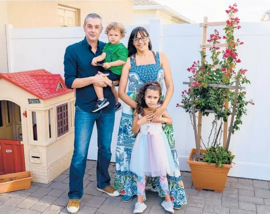  ?? TODD ANDERSON/THE NEW YORK TIMES ?? Ada Ayala and her husband, Oscar Cesar Pleguezeul­os, along with their children, Oscar and Charlise, at home in Winter Garden, Florida.