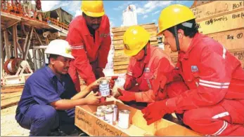  ?? TONG JIANG / FOR CHINA DAILY ?? Technician­s from Sinopec and local African workers at an oil exploratio­n site in Sudan.