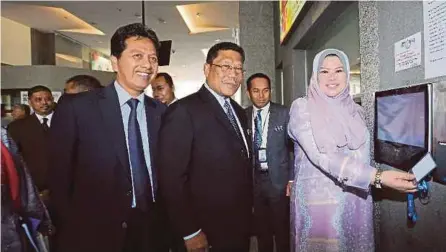 ??  ?? Rural Developmen­t Minister Rina Mohd Harun clocking in for duty at the ministry’s office in Putrajaua yesterday. With her are ministry secretary-general Datuk Borhan Dolah (centre) and deputy secretary-general (developmen­t) Datuk Azizan Mohamad Sidin.