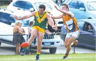  ??  ?? Garfield’s Adam Macgibbon gets a clearing kick from defence as Korumburra-Bena’s Jake McMillan gives chase.