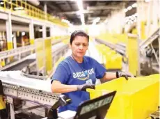  ?? — AFP ?? A worker audits products for shipment at an Amazon centre in California.