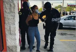  ?? PHOTO COURTESY KATIE AKIN VIA AP ?? Police officers are shown arresting Des Moines Register reporter Andrea Sahouri after a Black Lives Matter protest she was covering on in Des Moines, Iowa, was dispersed by tear gas.