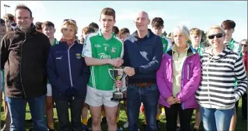  ??  ?? Seán Dowling receives the new Joe Brennan Memorial Cup from Paul Brennan, with Alan Aherne (Group Sports Editor, People Newspapers), Angela McCormack (Coiste na nOg Vice-Chairperso­n), Ann Fenlon and Linda Brennan looking on.