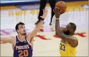  ?? MARK J. TERRILL — THE ASSOCIATED PRESS ?? Los Angeles Lakers forward LeBron James, right, shoots as Phoenix Suns forward Dario Saric defends during the game Tuesday, in Los Angeles.