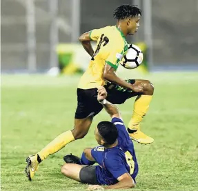  ?? RICARDO MAKYN/MULTIMEDIA PHOTO EDITOR ?? Jamaica’s Peter-Lee Vassell skips over Cayman Islands defender Wesley Robinson during their Concacaf Nations League clash at the National Stadium on Sunday night.