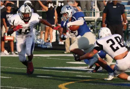  ?? RANDY MEYERS — THE MORNING JOURNAL ?? Midview’s Alonzo Banks is stopped by Naz Bohannon and Aaron Huff of Lorain after a short gain during the first quarter on Aug. 26.