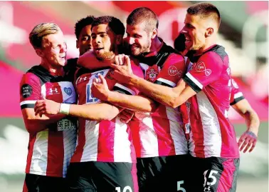  ?? AP ?? Southampto­n’s Che Adams (second left) is congratula­ted by teammates after scoring his team’s first goal during the English Premier League soccer match between Southampto­n and Manchester City at St Mary’s Stadium in Southampto­n, England, Sunday, July 5, 2020.