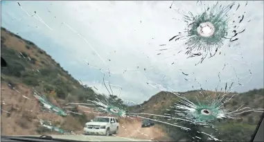  ?? [CHRISTIAN CHAVEZ/ THE ASSOCIATED PRESS] ?? Bullet-riddled vehicles that members of the extended LeBaron family were traveling in sit parked Wednesday on a dirt road near Bavispe, Mexico. Three women and six of their children, related to the extended LeBaron family, were gunned down in an attack while traveling here Monday.