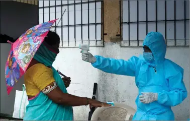  ?? REUTERS ?? A healthcare worker checks the temperatur­e and pulse of a resident during a check-up camp for the coronaviru­s disease, in Mumbai on Saturday.