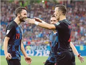  ?? [ FOTO EPA-EFE ] ?? Ivan Perisic (kanan) meraikan gol kemenangan bersama Milan Badelj (kiri) ketika Croatia menewaskan Iceland, kelmarin. Badelj menjaringk­an gol pertama pasukannya.
