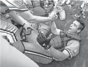  ?? AP ?? Mississipp­i catcher Nick Fortes (7) is helped up after celebratio­n when the Rebels won the Southeaste­rn Conference tournament on Sunday.