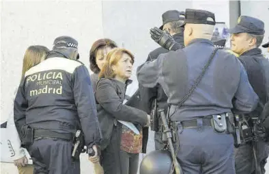  ?? JAVIER LIZÓN / EFE ?? Agentes de la Policía Nacional y Municipal conversan con varias mujeres durante un desahucio en Madrid.