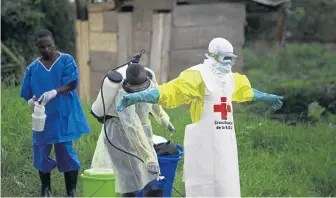  ?? AP FILE ?? VITAL CLEAN-UP: A health worker sprays disinfecta­nt on his colleague after working at an Ebola treatment center in Beni, Eastern Congo in September. Sometimes violent community resistance is complicati­ng efforts to contain Congo’s latest Ebola outbreak, causing the rate of new cases to rise.