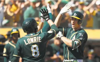  ?? Tony Avelar / Associated Press ?? Stephen Piscotty (right) and Jed Lowrie are two of only three A’s players in the everyday lineup who have been to the playoffs. Catcher Jonathan Lucroy is the other.