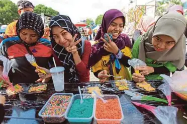  ??  ?? PENGUNJUNG berpeluang menghias biskut mengikut kreativiti sendiri.