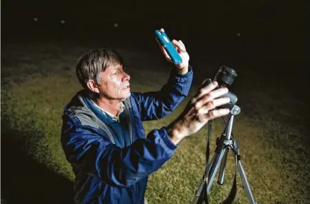  ?? Photos by Marie D. De Jesús / Staff photograph­er ?? Charles Phillips opens the Orbitrack app on his cellphone and waits for a satellite to move over the horizon near his home.