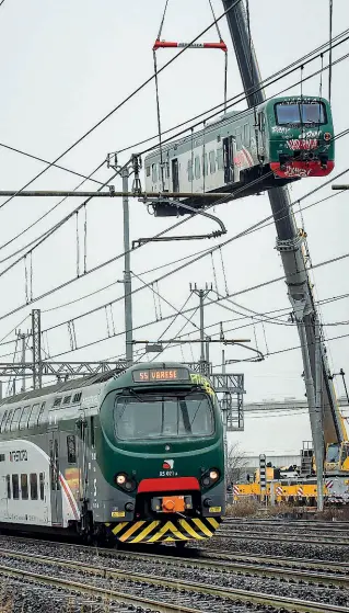  ??  ?? In volo La prima carrozza del treno Cremona-Milano viene rimossa con l’uso delle gru