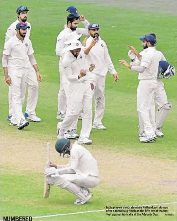  ?? REUTERS ?? ■ India players celebrate while Nathan Lyon slumps after a tantalisin­g finish on the fifth day of the first Test against Australia at the Adelaide Oval.