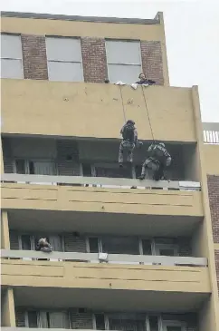  ?? DAVE THOMAS / POSTMEDIA NEWS ?? Toronto’s ETF rappel from the roof of a building on Church Street. Ellis Kirkland, 60, sat on the edge of a balcony
high above the street as police tried to talk her down. She is a suspect in the stabbing of a 67-year- old man.