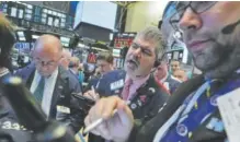  ?? Richard Drew, The Associated Press ?? Trader John Panin, center, works on the floor of the New York Stock Exchange on Thursday.