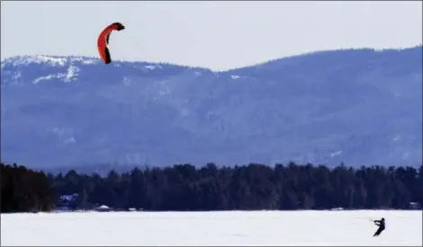 ?? JIM COLE — THE ASSOCIATED PRESS FILE ?? This file photo shows Jim Cline kite skiing over frozen Lake Winnipesau­kee in Tuftonboro, N.H.