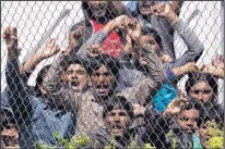  ?? PETROS GIANNAKOUR­IS/THE ASSOCIATED PRESS ?? Migrants at the Moria camp on the Greek island of Lesbos protest Tuesday against the deportatio­ns deal between the European Union and Turkey.