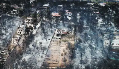  ?? ANTONIS NICOLOPOUL­OS / EUROKINISS­I VIA REUTERS CANADA ?? An aerial view shows burned houses and trees following a wildfire in the village of Mati, near Athens, Greece, on Wednesday.