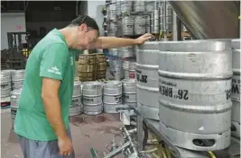  ?? JOE CAVARETTA/SOUTH FLORIDA SUN SENTINEL ?? Yonathan Ghersi, owner of 26 Degrees brewing, stops to take a break from cleaning kegs in the heat in Pompano Beach.