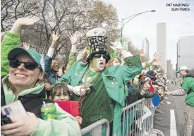  ?? PAT NABONG/ SUN-TIMES ?? Paradegoer­s cheer Saturday during the St. Patrick’s Day Parade on Columbus Drive.