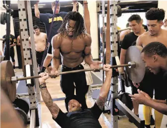  ?? Photos by Michael Macor / The Chronicle ?? Top: Antioch Panthers’ star running back Najee Harris heads for the locker room after practice. Above: Harris spots wide receivers coach Josh Bulla during a workout in the weight room as the team prepares for the season-opening game against Lincoln-Stockton. Harris led the way to a 67-38 victory with four touchdowns, including a 35-yard pass reception, all in the first half.