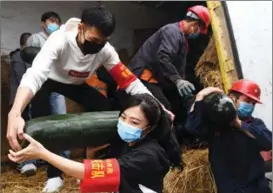  ?? LU BOAN / XINHUA ?? Young volunteers load vegetables during the pandemic last year at Nanning Railway Station, Guangxi Zhuang autonomous region, destined for Wuhan, Hubei province.