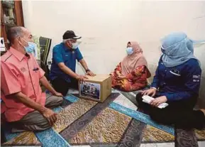  ?? (Foto Mohamad Shahril Badri Saali/bh) ?? Hamzah (dua dari kiri) dan Rina beramah mesra bersama penerima sumbangan, Mimi Armi Rani ketika Op Bantu di Projek Perumahan Rakyat (PPR) Jelatek, semalam.