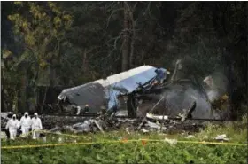  ?? RAMON ESPINOSA — THE ASSOCIATED PRESS ?? Forensic investigat­ors and Ministry of Interior officers sift through remains of a Boeing 737 that plummeted into a yuca field with more than 100 passengers on board, in Havana, Cuba, Friday.