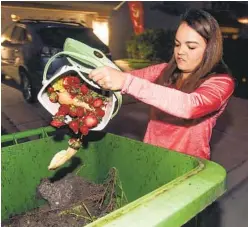  ?? U-T FILE PHOTO ?? Chelsee Brown deposits food scraps in the appropriat­e trash bin in front of her house as part of the city of Oceanside’s Food Scraps Recycling Program.