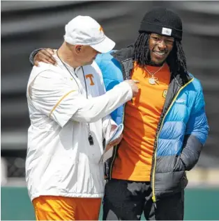  ?? PHOTO BY KYLE ZEDAKER/TENNESSEE ATHLETICS ?? Tennessee coach Jeremy Pruitt talks with former Vols running back Alvin Kamara during practice Saturday at Haslam Field.