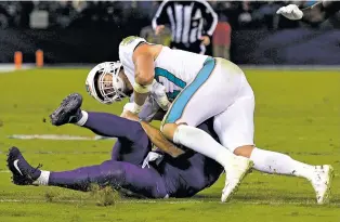  ?? NICK WASS/THE ASSOCIATED PRESS ?? Dolphins linebacker Kiko Alonso, top, collides with Ravens quarterbac­k Joe Flacco on Thursday in Baltimore. Flacco left the game before halftime, entering the concussion protocol during the Ravens’ 40-0 win.