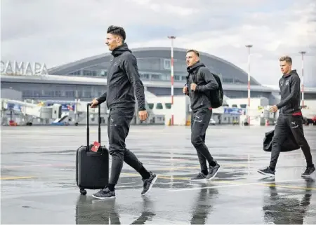  ?? AFP ?? Fabian Schär, Josip Drmic und Nico Elvedi (v. l.) haben soeben das Flugzeug verlassen und machen sich auf zum Teambus.