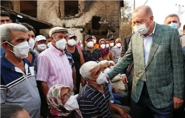  ?? FOTO: PA / ASSOCIATED PRESS ?? Der türkische Präsident Recep Tayyip Erdogan (r.) reiste in vom Feuer niedergebr­annte Gebiete und sprach den Bewohnern Mut zu.