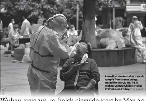  ??  ?? A medical worker takes a swab sample from a man being tested for the COVID-19 in Wuhan,Central China’s Hubei Province, on Friday.